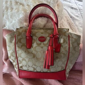 New Coach handbag with zipper top that comedies with an adjustable strap